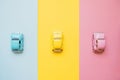 Small color toy cars on a yellow, pink and blue background. Business competition, winners and losers. Finish line Royalty Free Stock Photo