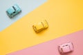 Small color toy cars on a yellow, pink and blue background. Business competition, winners and losers. Finish line Royalty Free Stock Photo