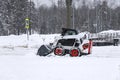 small color tractor clearing snow side view