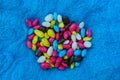 Small colored candy pebbles in a pile on blue cloth