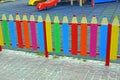 A small colored decorative fence in the form of pencils on the playground Royalty Free Stock Photo