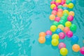 Small colorful beach balls floating in swimming pool abstract concept for pool party s. Royalty Free Stock Photo