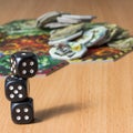 Small column of three dark dice on the surface of a wooden table