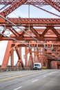 Small commercial cargo mini van running on the big red truss Broadway bridge