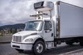 Small compact rig semi truck with refrigerated box trailer running on the road for local deliveries Royalty Free Stock Photo