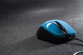 Small computer mouse plastic. Blue color. Black background. Black wire. A blank space for an inscription. Electronics. Royalty Free Stock Photo