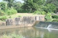 A small concrete dam spans the river. Royalty Free Stock Photo