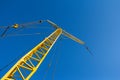 A small construction crane on a background of blue sky. Industrial background Royalty Free Stock Photo