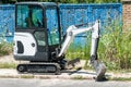 Small construction machinery excavator or earth mover with digging shovel and scoop parked on the street in the city