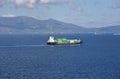 Small container ship sailing near sea coast close to Gibraltar. Royalty Free Stock Photo