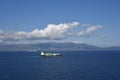 Small container ship sailing near sea coast close to Gibraltar. Royalty Free Stock Photo