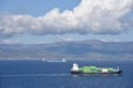 Small container ship sailing near sea coast close to Gibraltar. Royalty Free Stock Photo