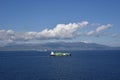 Small container ship sailing near sea coast close to Gibraltar. Royalty Free Stock Photo