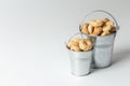 Small cooked snacks in two iron retro buckets. Proper nutrition. On white background.