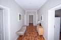 small corridor grey wall wooden floor, white flowers, sofa, cupboard, door
