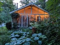 Small Cottage with Porch Twinkle Lights and surrounded by gardens Royalty Free Stock Photo