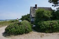 Small cottage with thatched roof between rose hedges by the sea Royalty Free Stock Photo