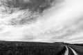 Small country road under big sky and white clouds Royalty Free Stock Photo