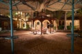 A small cozy gazebo is illuminated by lanterns at night. A place for a night out on the beach Royalty Free Stock Photo