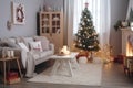 Small cozy living room in light colors with Christmas tree. Royalty Free Stock Photo