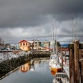 The small craft harbor office and boats at the fisherman's wharf reflected in the winter ocean water