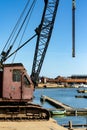 A small crane mounted on the edge of the River Deben used to move boats in and out of the river and to suspend while cleaning and