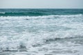 Small cresting wave in the Atlantic Ocean on the coast. Blue green ocean waves with sea foam and salt water spray. Beach travel Royalty Free Stock Photo