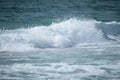 Small cresting wave in the Atlantic Ocean on the coast. Blue green ocean waves with sea foam and salt water spray. Beach travel Royalty Free Stock Photo