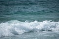 Small cresting wave in the Atlantic Ocean on the coast. Blue green ocean waves with sea foam and salt water spray. Beach travel Royalty Free Stock Photo