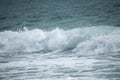 Small cresting wave in the Atlantic Ocean on the coast. Blue green ocean waves with sea foam and salt water spray. Beach travel Royalty Free Stock Photo