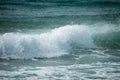 Small cresting wave in the Atlantic Ocean on the coast. Blue green ocean waves with sea foam and salt water spray. Beach travel Royalty Free Stock Photo