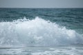 Small cresting wave in the Atlantic Ocean on the coast. Blue green ocean waves with sea foam and salt water spray. Beach travel Royalty Free Stock Photo