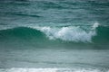 Small cresting wave in the Atlantic Ocean on the coast. Blue green ocean waves with sea foam and salt water spray. Beach travel Royalty Free Stock Photo