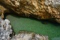 Small croatian shore cove hidden between steep cliffs with clear azure water