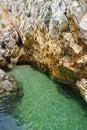 Small croatian shore cove hidden between steep cliffs with clear azure water