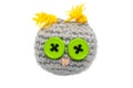 Small crocheted owl toy of gray threads with yellow ears, a pink nose and eyes of green buttons isolated on a white background Royalty Free Stock Photo