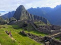 A small crowd of tourists admire the incredible sights of Machu Picchu in Peru.