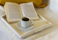 A small Cup of coffee and an open book against a warm blanket.The concept of relaxing in a cozy home environment
