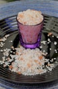 Small cup with pink Himalayan salt under the plate Royalty Free Stock Photo