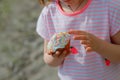 small cupcake similar to an Easter panettone in hands of girl in pink T-shirt