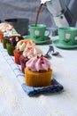 Small cupcakes in a row on a folded towel with a person pouring coffee in the background Royalty Free Stock Photo