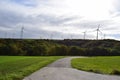 small curvy road to wind power generators on the hill Royalty Free Stock Photo