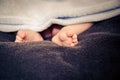 Small, cute baby feet peeking out from a blanket Royalty Free Stock Photo