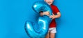 Small cute blonde boy on blue background holding foil-coated sphere baloon blue colour. happy birthday three years old Royalty Free Stock Photo