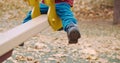 Small, cute child rides on a swing in the yard on a walk. Legs close up