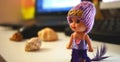 Small cute doll with purple dress and sweat hat