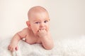 Small cute funny baby infant teething with face expression hands and fingers in mouth sore gums Royalty Free Stock Photo