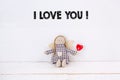 Puppet sitting doll with a red heart and text `I love you` on a white background. Royalty Free Stock Photo