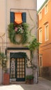 cute street in Italy, front door and window lots of flowers and green hanging plants in the window, decoration,
