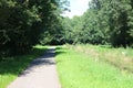Small cycle lane between grass and trees in Park Hitland in Nieuwerkerk aan den IJssel in the Netherlands.